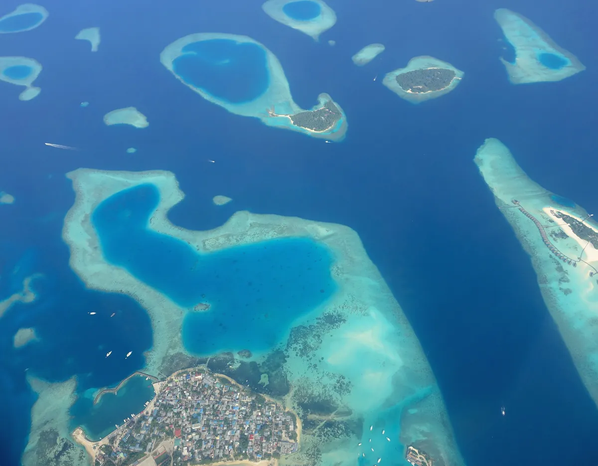 Aerial view of coral reefs and lagoons in a Maldives atoll